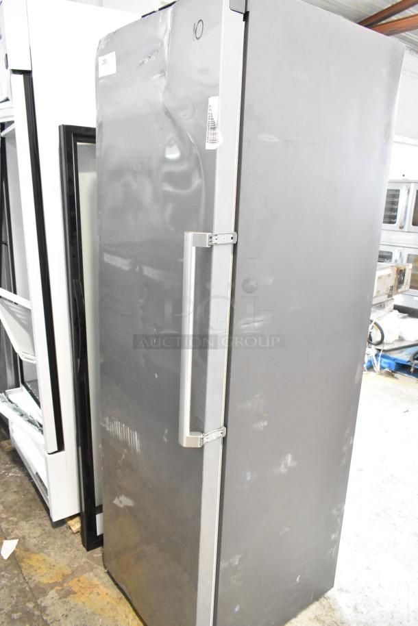 Samsung RZ11M7074SA stainless steel single door freezer, 115V, 1 phase. Notable dents on exterior surface. Model tag visible.