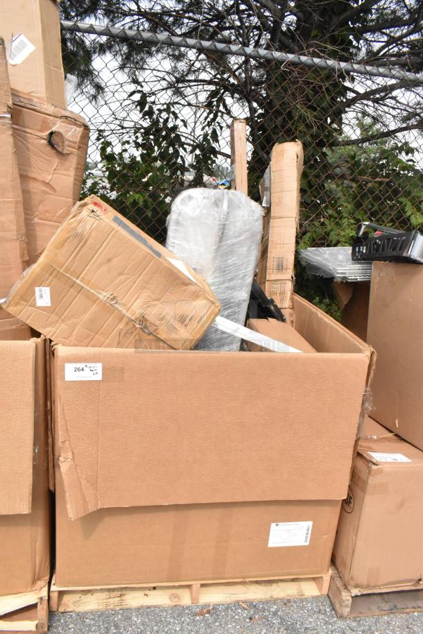 Stacked cardboard boxes with visible dents and shipping labels contain 14 new scratch and dent auction items, including Lavex mop bucket combo.