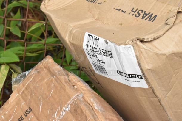 Damaged cardboard boxes with a label reading "Carlisle 077703 12 Tortilla Server Black Each." Box corner is bent.
