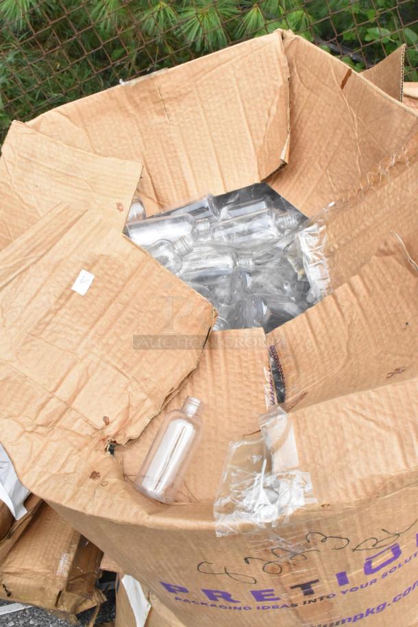 Damaged cardboard box containing various clear plastic bottles, indicative of scratch and dent condition for auction.