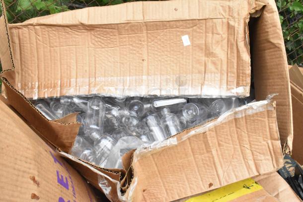 Open carton containing clear plastic bottles. Boxes show signs of wear, indicating scratch and dent condition.