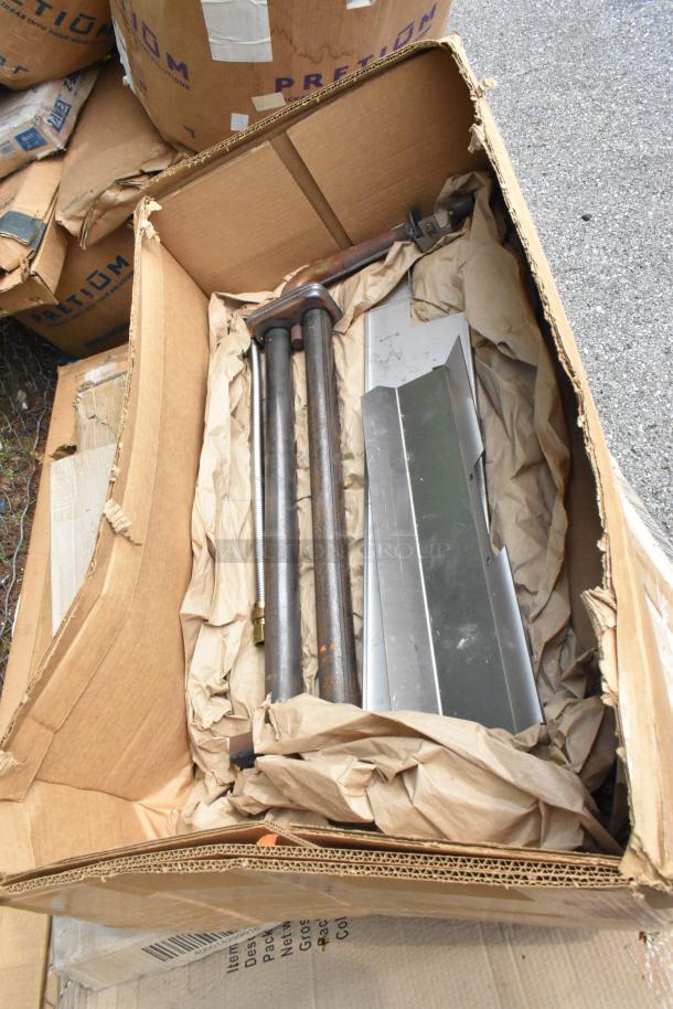 Cardboard box containing metal legs and table parts, part of 8 new scratch and dent auction items.