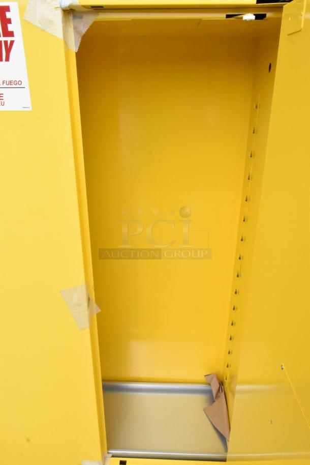 Brand new yellow metal 2-door cabinet, with minor dents. Interior and adjustable shelving visible. Safety label attached.