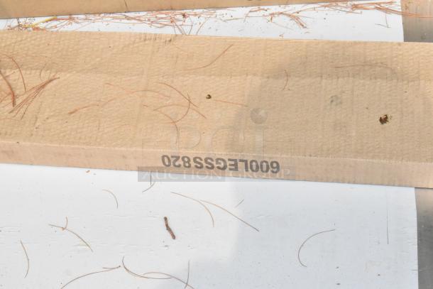 Cardboard packaging with label "600LCGS820" visible, containing Regency 600ST3072R stainless steel table with single bay sink.