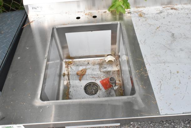 Stainless steel Regency 600ST3096L table with single bay sink; scratch and dent condition, some debris visible.