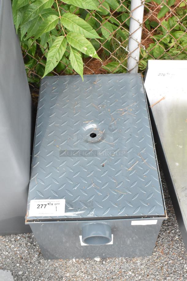 Brand new Watts WD-20 grease interceptor, 40 lb capacity, with minor scratches and dents, diamond plate lid, visible piping.