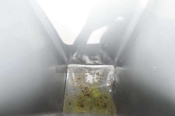 Brand new gray poly trash can with visible water and debris at the bottom; scratch and dent condition.