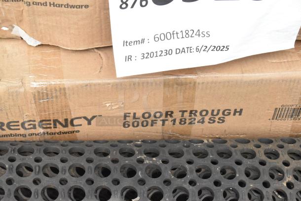 Cardboard box labeled "Regency FLOOR TROUGH 600FT1824SS," with worn edges showing wear. Grate with circular holes visible.