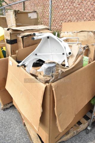 Boxes of scratch and dent items including white table parts, opened and damaged packaging visible.