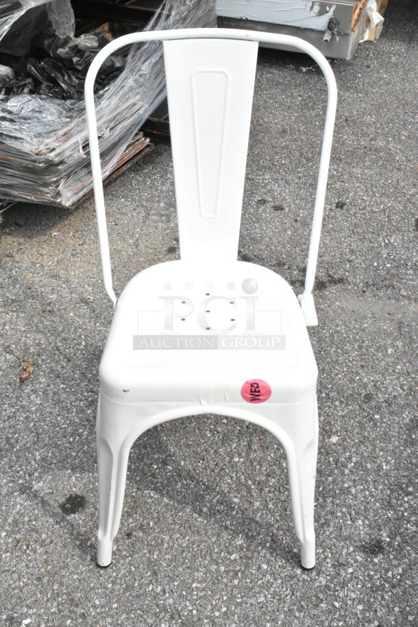 White metal chair with a curved back and perforated seat. Pink "WE15" sticker on the front. Outdoor use.