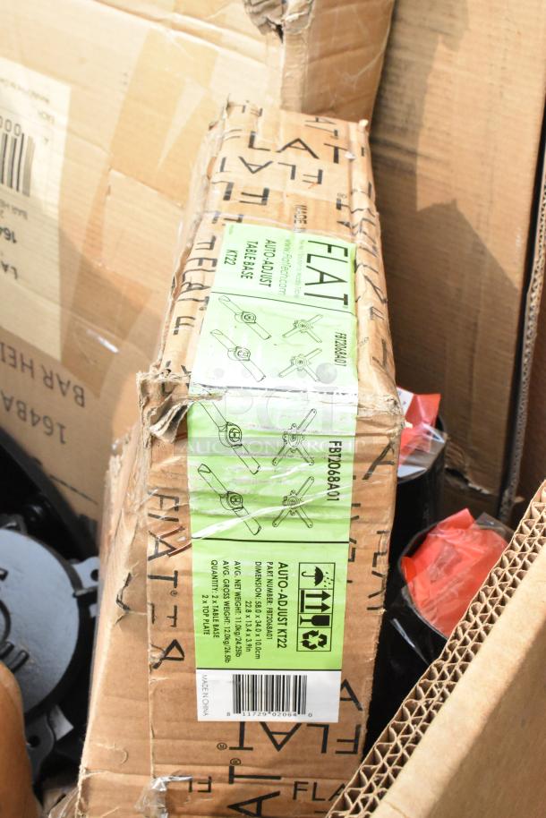 Box of 15 new scratch and dent items including FLAT Tech auto-adjust table bases, visible green label with specs and barcode.