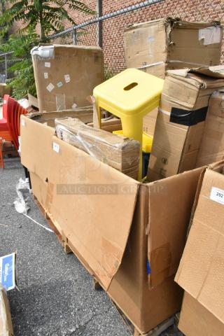 Cardboard boxes containing new scratch and dent items, including a yellow Tolix style stool, visible outside.