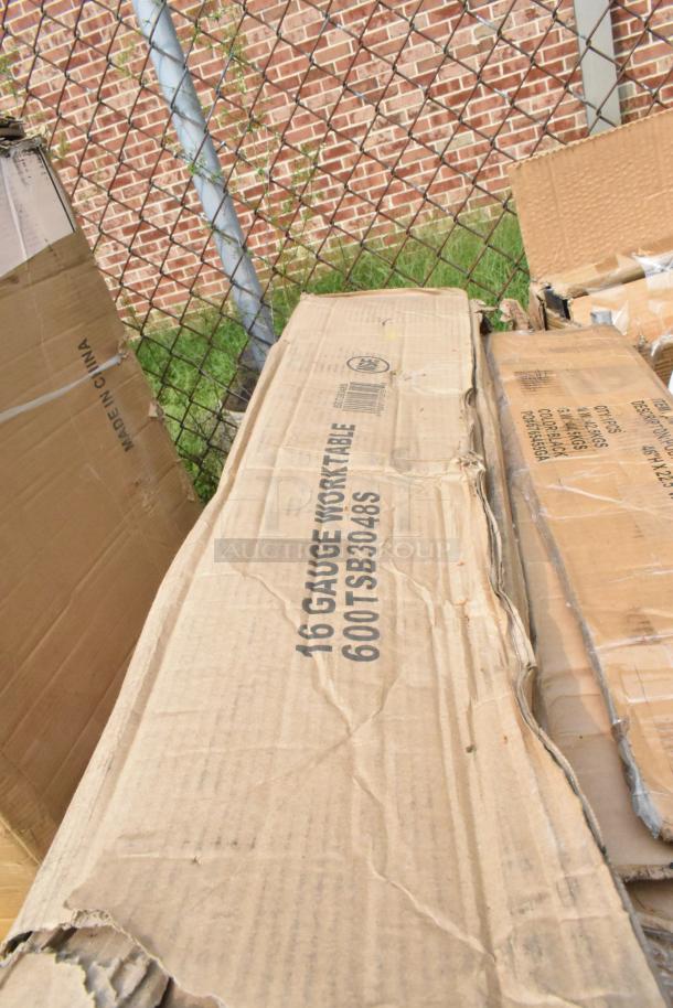 Cardboard box labeled "16 Gauge Work Table 600TSB3048S" in a scratch and dent condition, outside packaging.