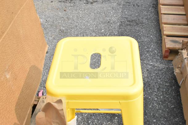 Yellow Tolix-style stool, brand new condition, with a square seat and central handle cutout.