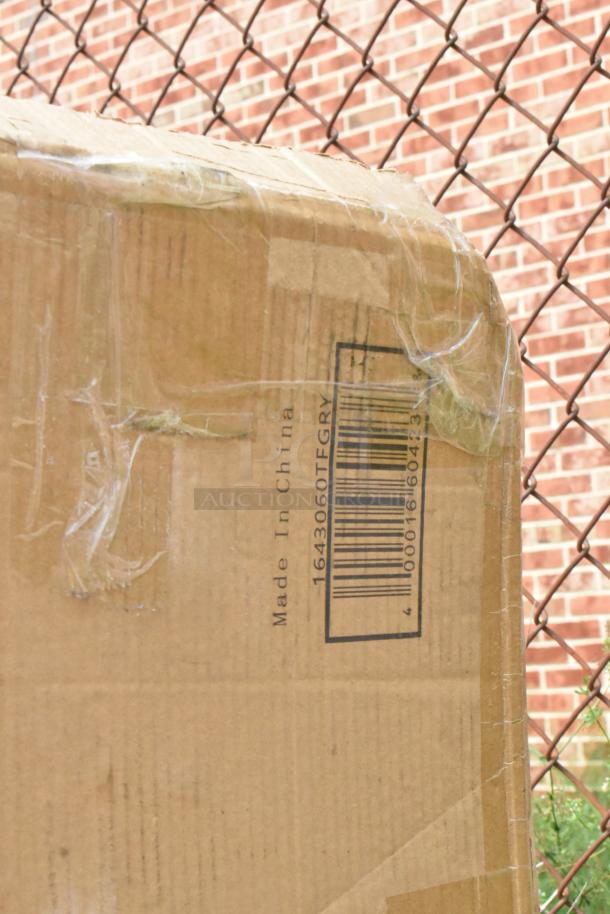 Cardboard box showing barcode "1643060TFGRY" and "Made in China", taped edges, in front of chain-link fence.
