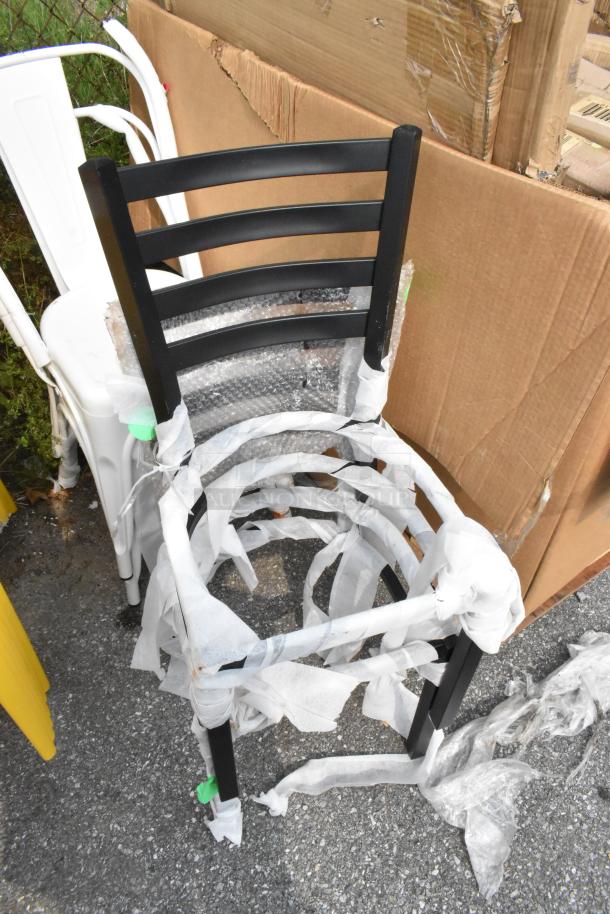 Brand new black metal ladder-back chair and white Tolix style chair, wrapped in packaging. Scratch and dent condition.
