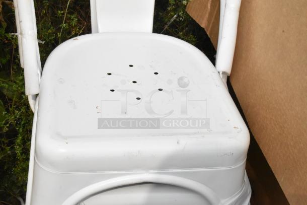 White Tolix style chair with minor scratches and dents. Backrest and seat visible, showing unique hole pattern design.