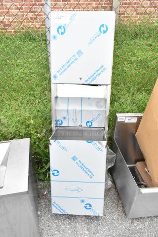 Brand new stainless steel towel dispenser and trash can with scratch and dent. Protective film visible, durable construction.