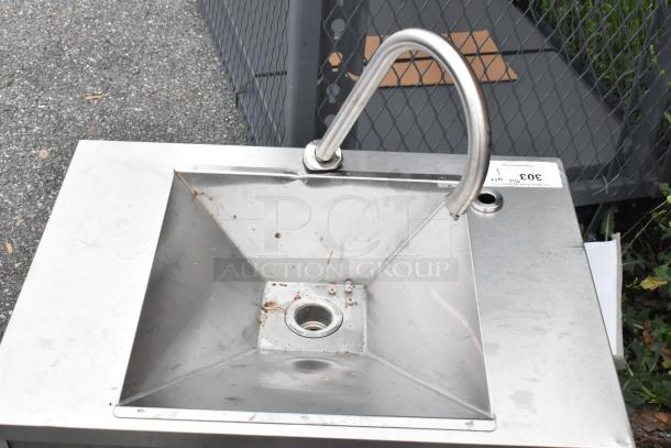 Stainless steel single bay sink with gooseneck faucet, minor surface rust, industrial setting, auction tag attached.