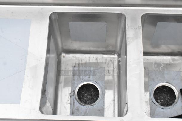 Brand new Regency 600S21014216 stainless steel 2-bay sink with dual drain boards, scratch and dent condition, no legs.