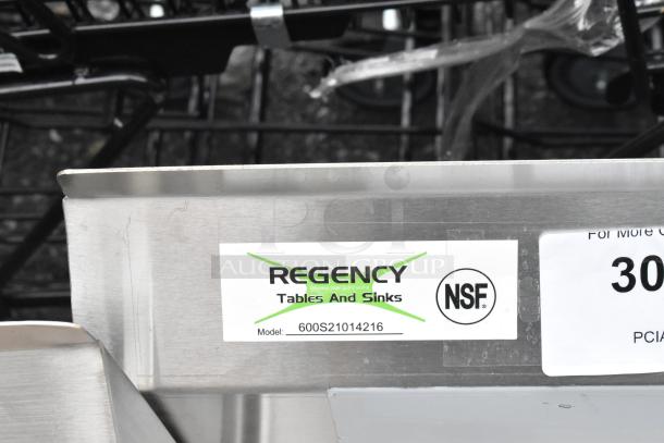 "Regency 600S21014216 stainless steel 2-bay sink, dual drain boards, scratch and dent condition, no legs, NSF certified."