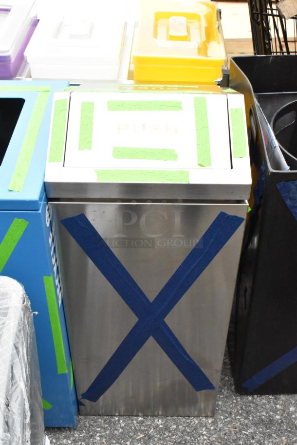 Black and chrome finish trash can, new with scratch and dent. "PUSH" label on lid, taped for protection.
