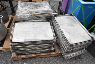 Pallet of metal full-size baking pans, showing signs of wear. Wrapped and stacked. Tag indicates "ALL ONE MONEY! QTY".