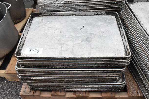 Pallet of metal full-size baking pans with slight wear; auction tag visible indicating lot number 312.