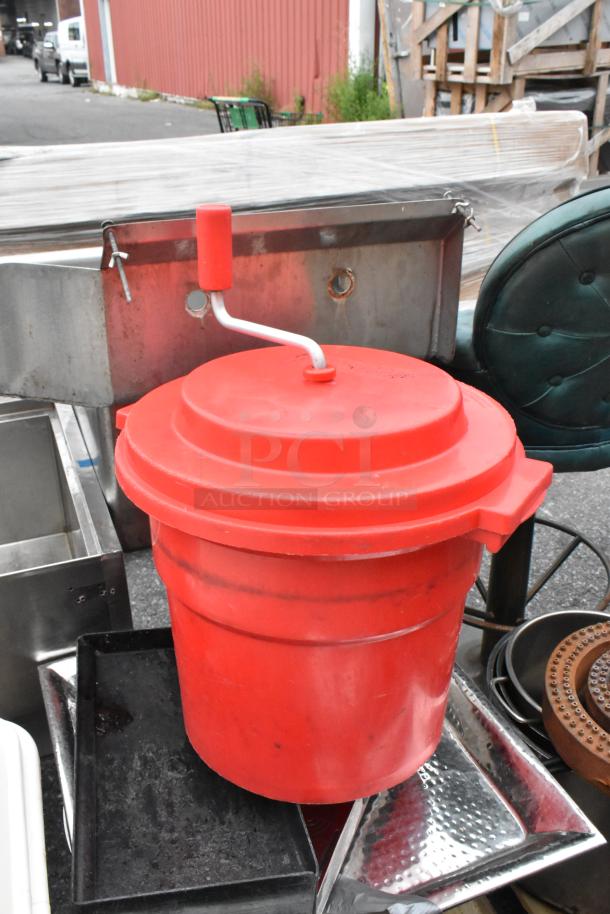 Red salad spinner on pallet with metal pots, burners, and gas hoses. Various items mixed, suitable for bulk purchase.