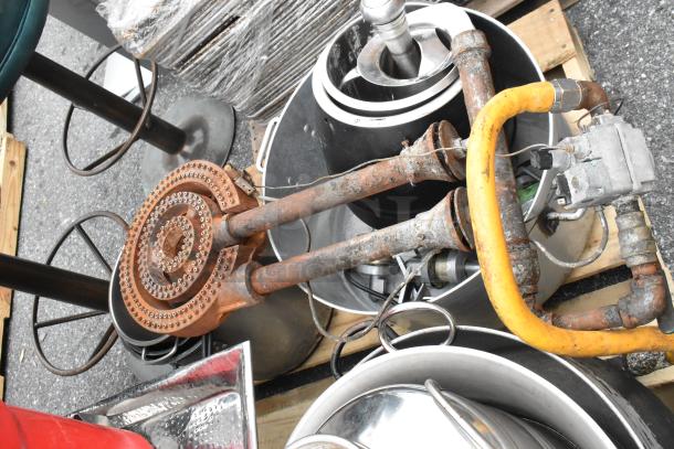 Pallet lot with red salad spinner, rusted metal pots, burners, and gas hoses. Items show wear, sold as a whole.