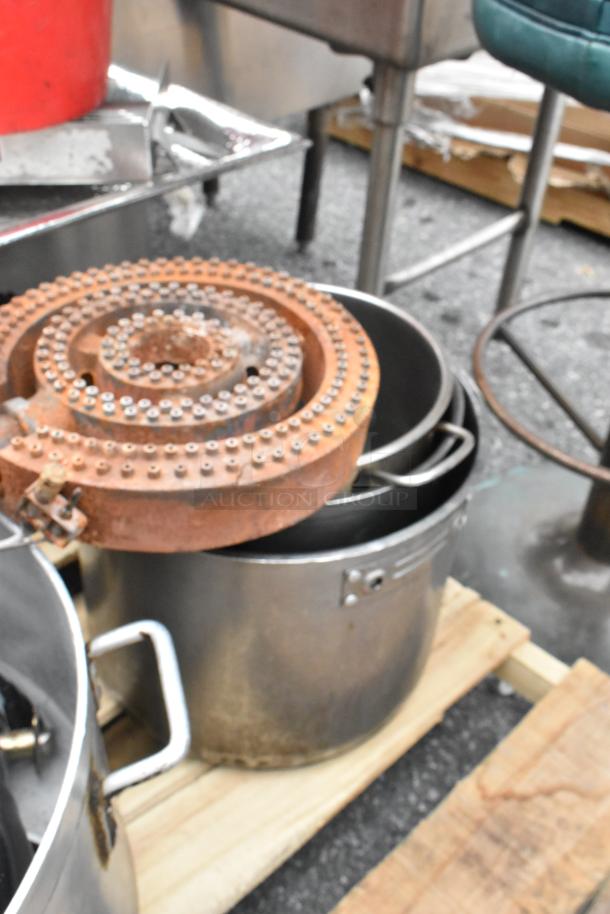 Pallet lot with red salad spinner, metal pots, rusty gas burner, and hoses. Items used, showing varying wear.