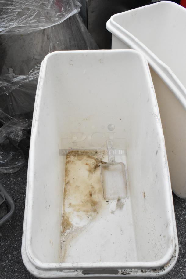 Two white poly ingredient bins on commercial casters, used condition with visible stains. Ideal for commercial storage.
