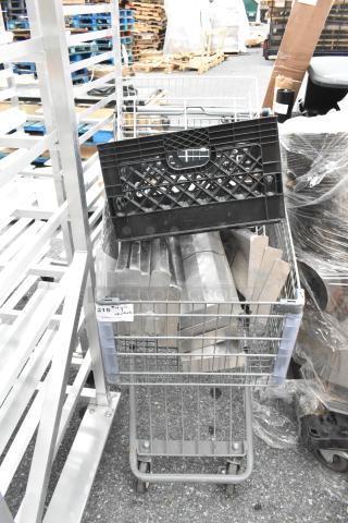 Gray shopping cart filled with metal pieces and a black plastic crate. Visible tag marked "315" indicates item lot number.