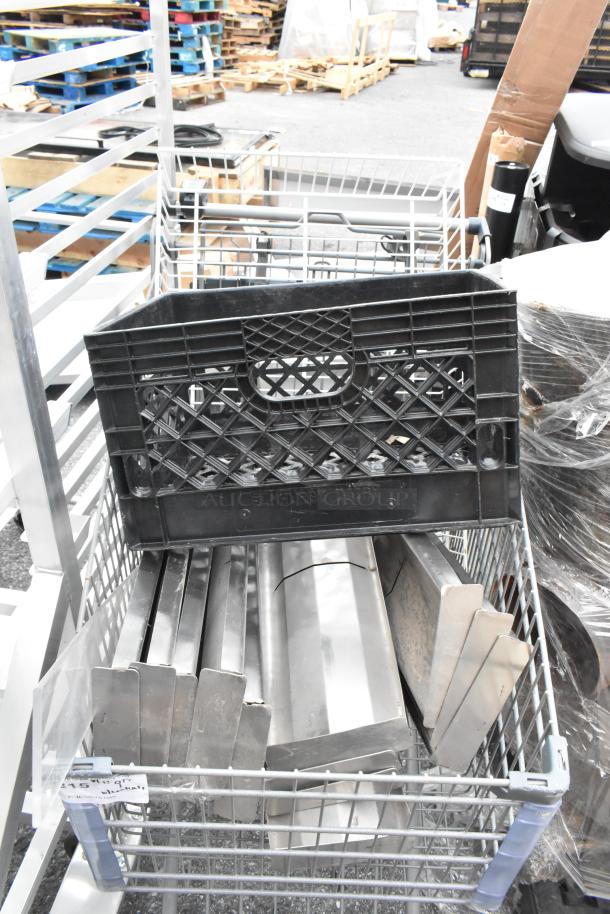 Gray shopping cart containing various metal pieces and a black plastic crate. Signs of wear visible.