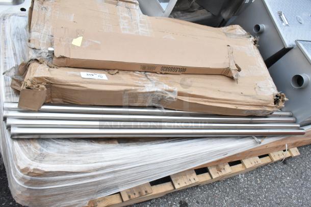 Six brand new Regency items including two grease traps, one stainless steel leg set, in damaged packaging on a pallet.