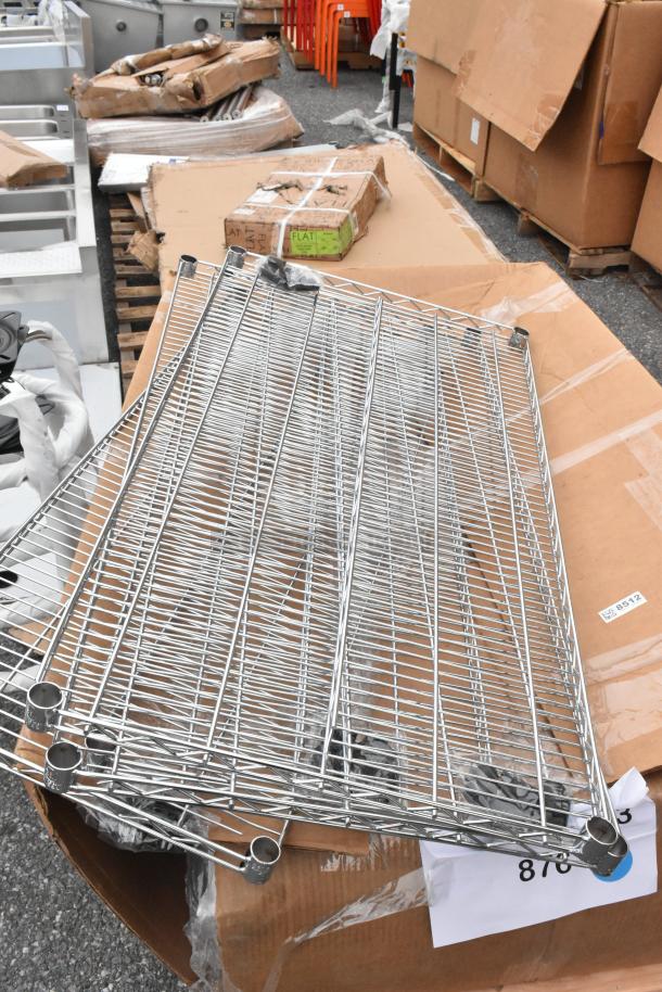 Brand new Regency 18" x 48" NSF chrome wire shelf, part of a mixed auction lot, shown in a warehouse setting.