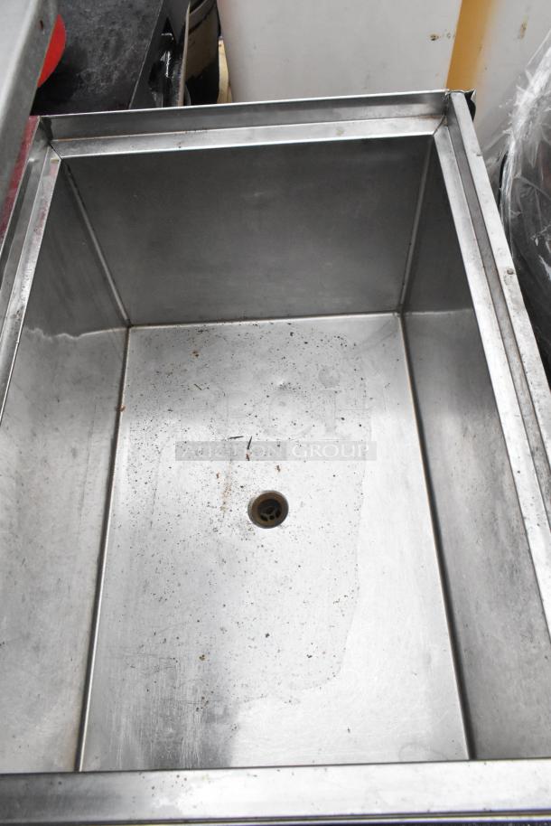 Stainless steel ice bin with drain hole, commercial grade, minor surface wear, ideal for bar or restaurant use.