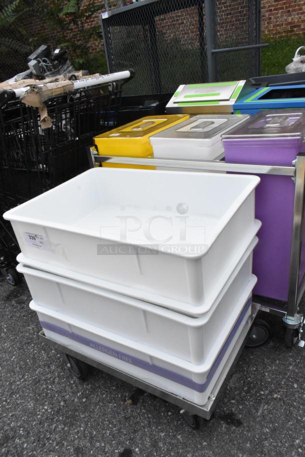 Two white poly dough bins on a dolly, accompanied by three colorful poly ingredient bins in a metal frame.