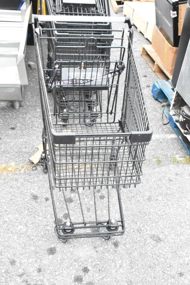 10 metal shopping carts with casters, lined up outdoors. Used condition, sturdy metal construction. Multiples of 10 per bid.