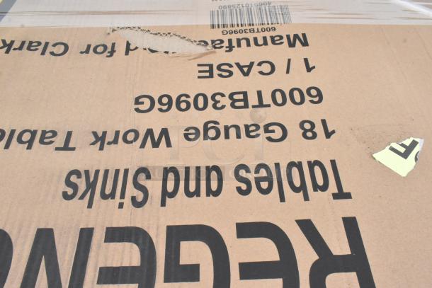Cardboard packaging for a Regency 18-gauge stainless steel work table, shows visible tear and printed text.