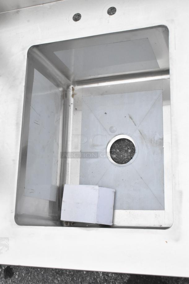 Brand new Regency 600ST3096L stainless steel table with single bay sink, visible scratches, and dents.