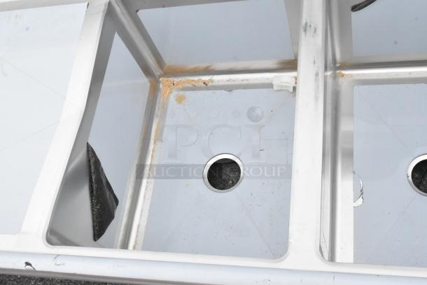 BRAND NEW Regency 600S31824224 stainless steel 3-bay sink with dual drain boards, minor scratches, no legs included.