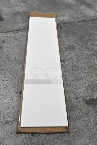 Brand new scratch and dent cutting board, white, long rectangular shape. Minimal blemishes, packaged on cardboard.