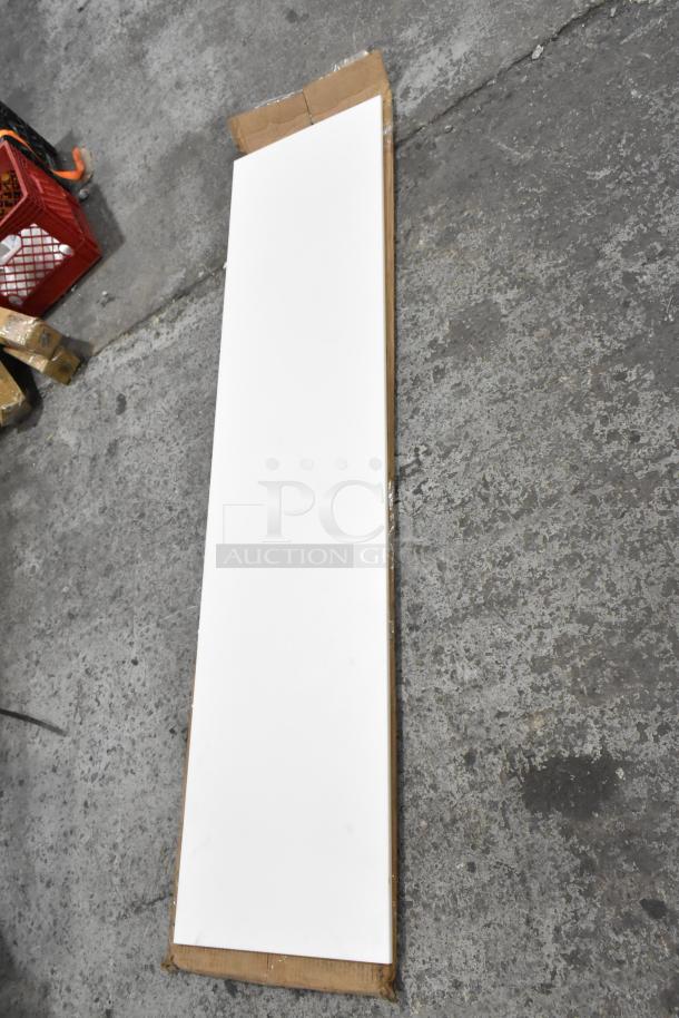 Brand new scratch and dent cutting board, white, rectangular, large size, visible cardboard packaging damage.