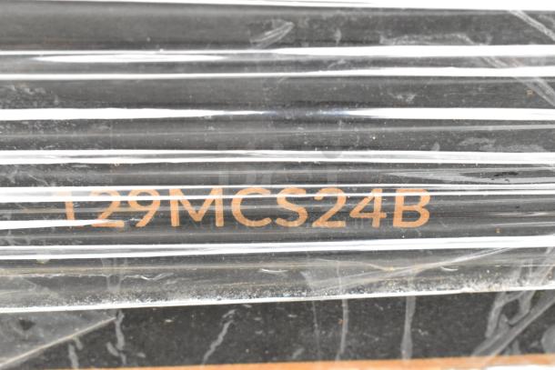 Image of black rods wrapped in plastic wrap, labeled "129MCS24B" in orange text, indicating inventory or product code.