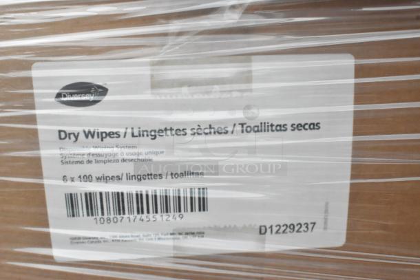 Cardboard box wrapped in plastic labeled "Diversey Dry Wipes" with barcode D1229237. Contains 6 packs of 100 wipes.