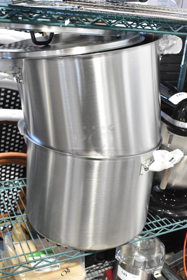 Four metal cookware pieces, including three stock pots and one colander/steam pot, in good condition.