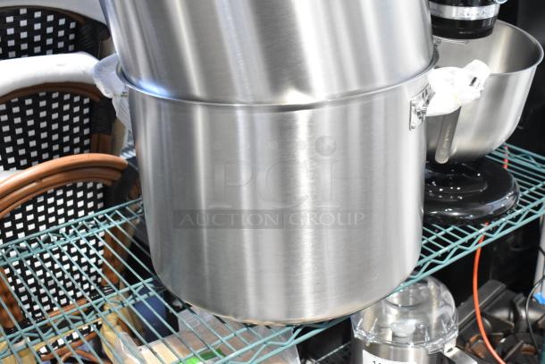 Four metal items including three stock pots and one colander/steam pot in excellent condition.