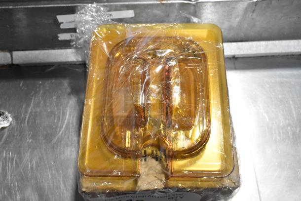 Amber colored poly 1/6 size drop-in bin lids, brand new with scratches and dents, wrapped in plastic packaging.