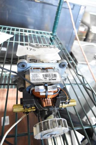 Brand new Bison 122485-00 motor on a metal shelf. Visible barcode and product details label, copper wiring.